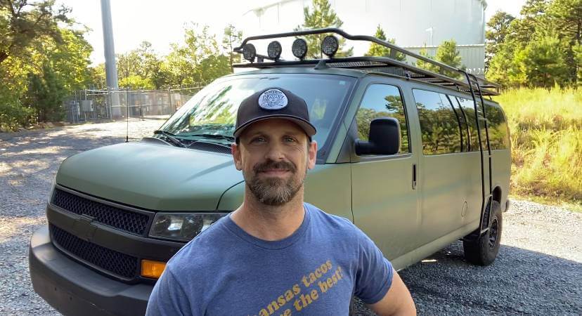 Man in front of Camper Van